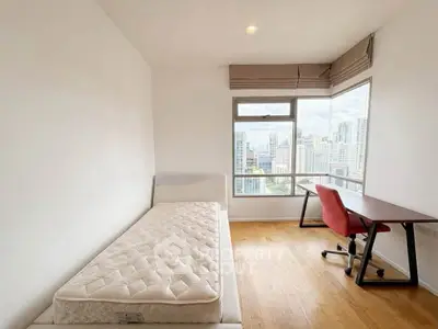 Bright bedroom with city view, featuring a single bed and study desk, ideal for urban living.