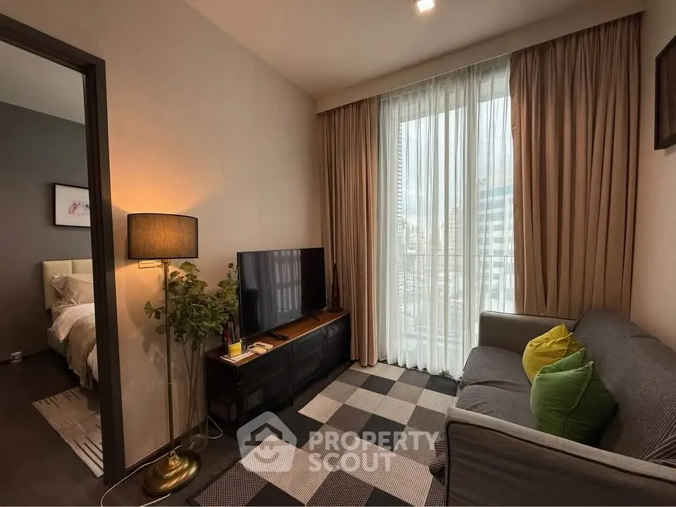 Cozy living room with modern decor and city view, featuring a comfortable sofa and stylish lighting.