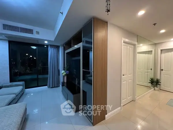 Modern living room with sleek design and large windows offering city views.