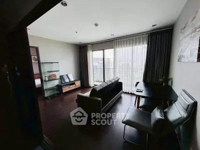 Modern living room with large windows and stylish furniture in a high-rise apartment.