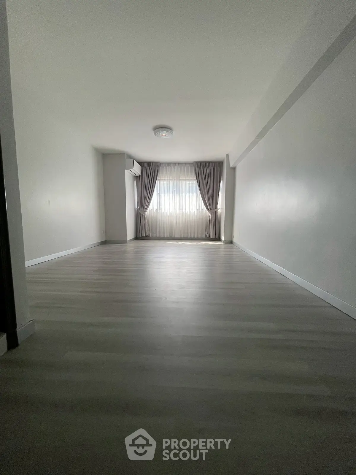 Spacious empty living room with large window and elegant curtains