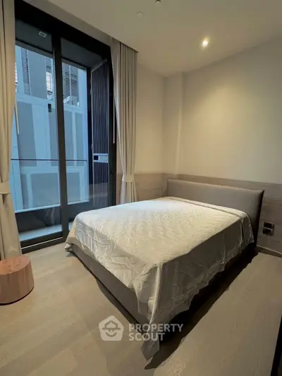 Modern bedroom with large window and minimalist decor in urban apartment