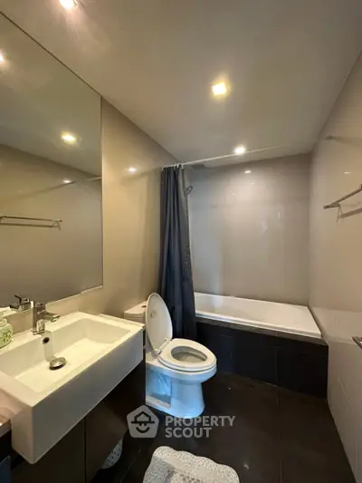 Modern bathroom with sleek fixtures and bathtub in contemporary apartment.