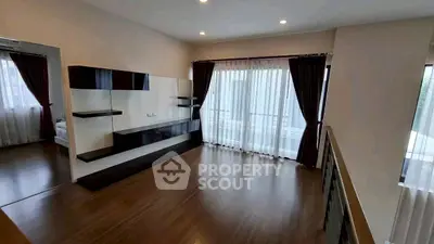 Spacious living room with modern shelving and large windows for natural light.
