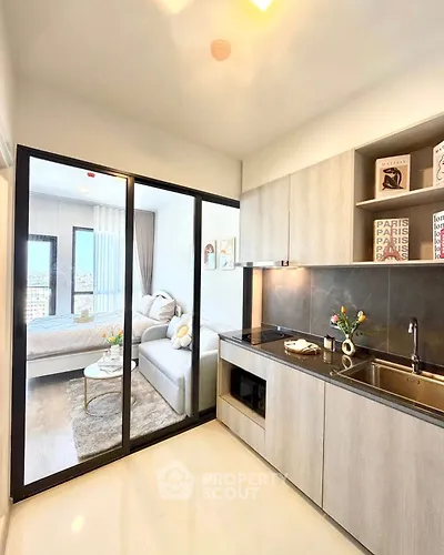 Modern open kitchen with sleek design and cozy living area in a stylish apartment.