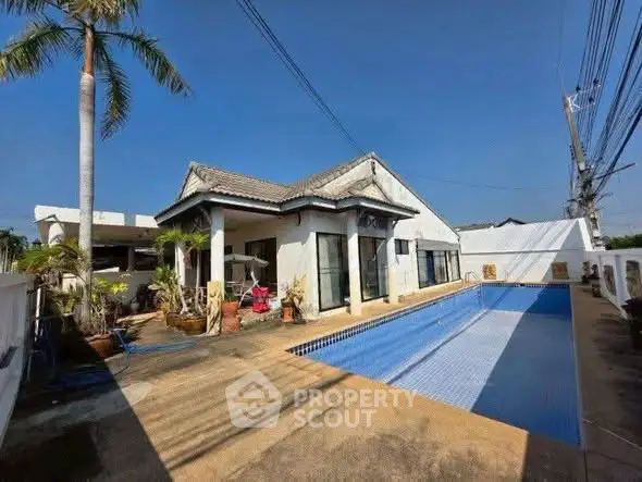 Charming villa with private pool and spacious outdoor area under clear blue sky.