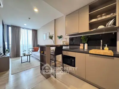 Modern open-layout kitchen and living room with stylish decor and natural light.