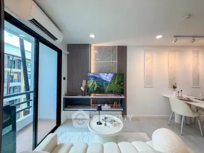 Modern living room with balcony view, stylish decor, and elegant dining area in a contemporary apartment.