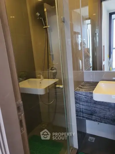 Modern bathroom with glass shower and stylish sink in a contemporary apartment.