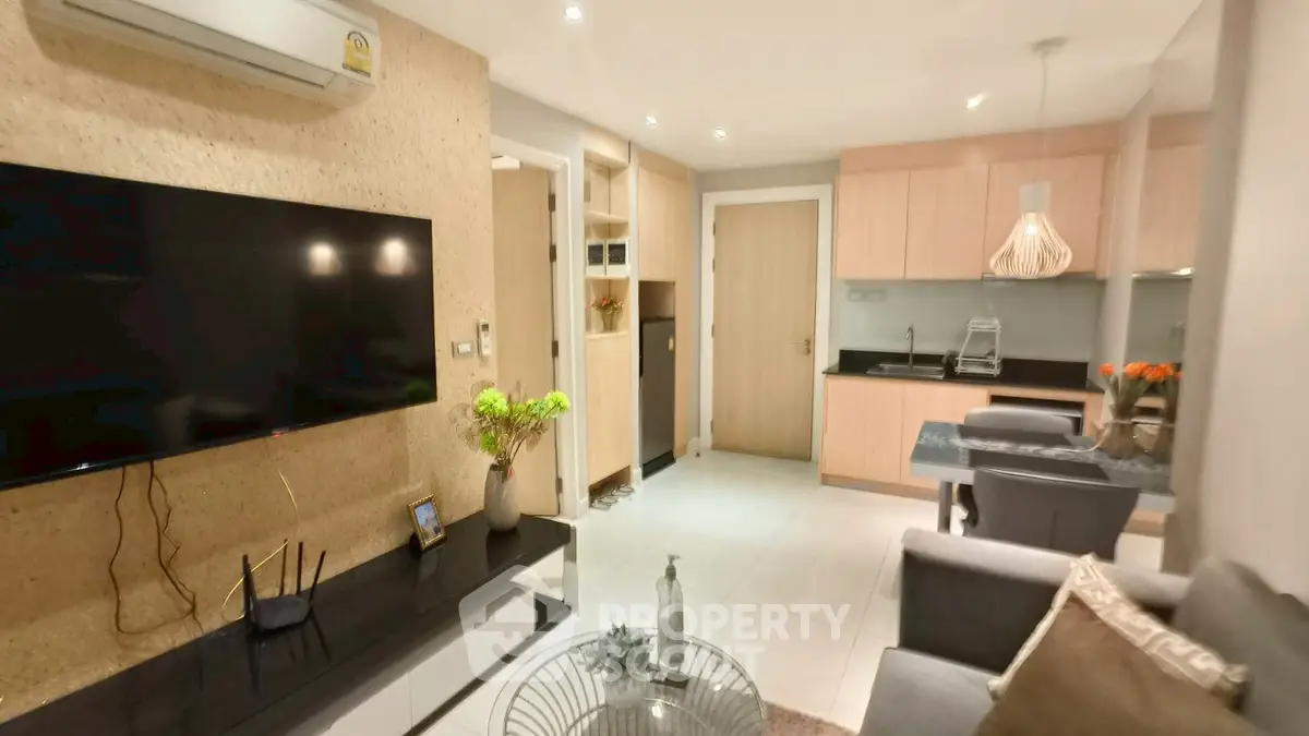 Modern living room with open kitchen, stylish decor, and cozy seating area.