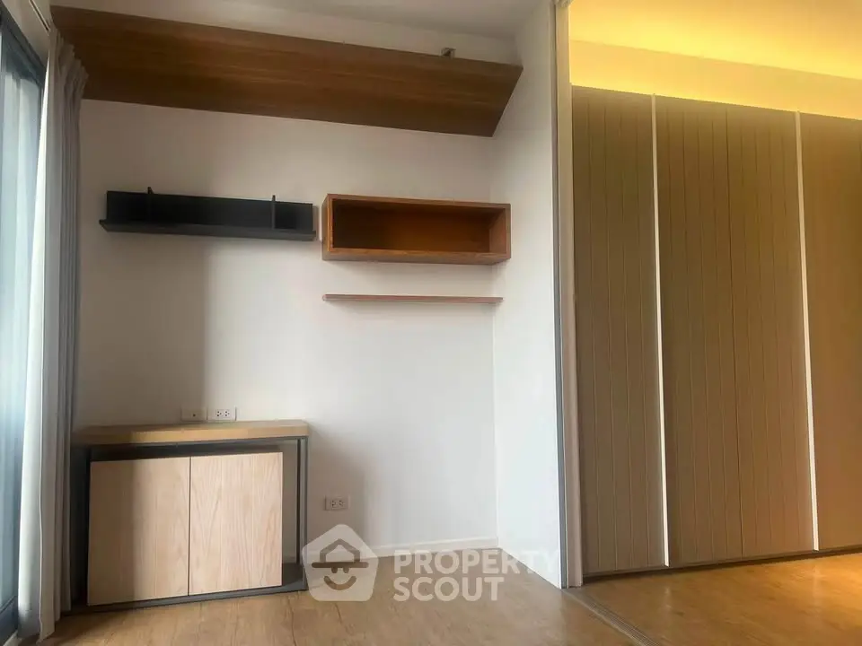 Modern minimalist room with wooden flooring and built-in shelves