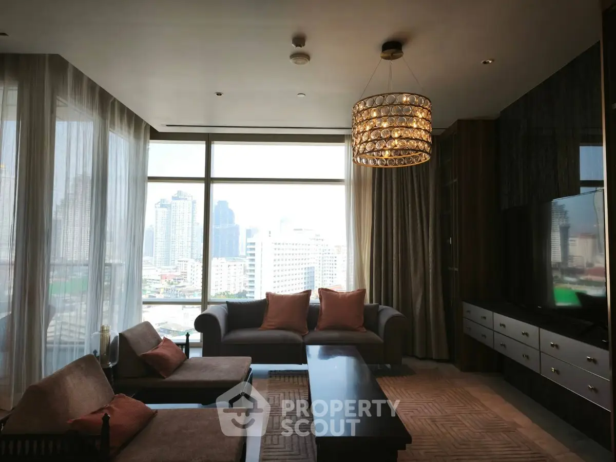 Luxurious living room with city view, elegant chandelier, and modern furnishings in high-rise apartment.