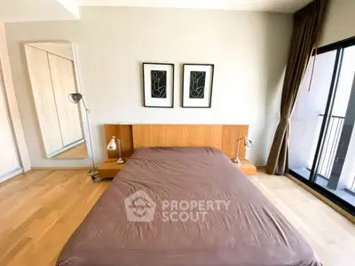 Spacious bedroom with modern decor and large window for natural light