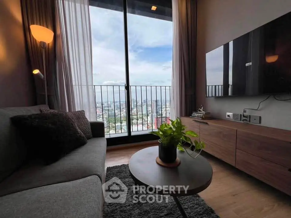 Stylish living room with city view, modern furniture, and cozy ambiance in high-rise apartment.