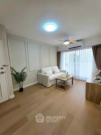 Spacious living room with modern decor and large window for natural light.