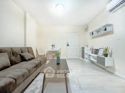 Modern living room with stylish furniture and decor, featuring a cozy sofa and elegant shelving.
