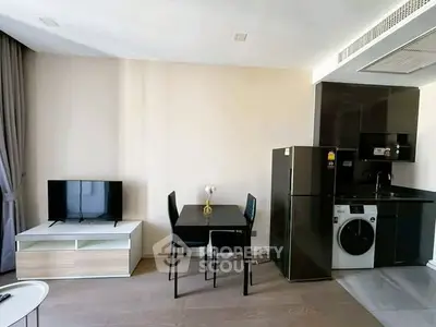 Modern apartment interior with sleek kitchen and cozy living area, featuring a washing machine and stylish furniture.