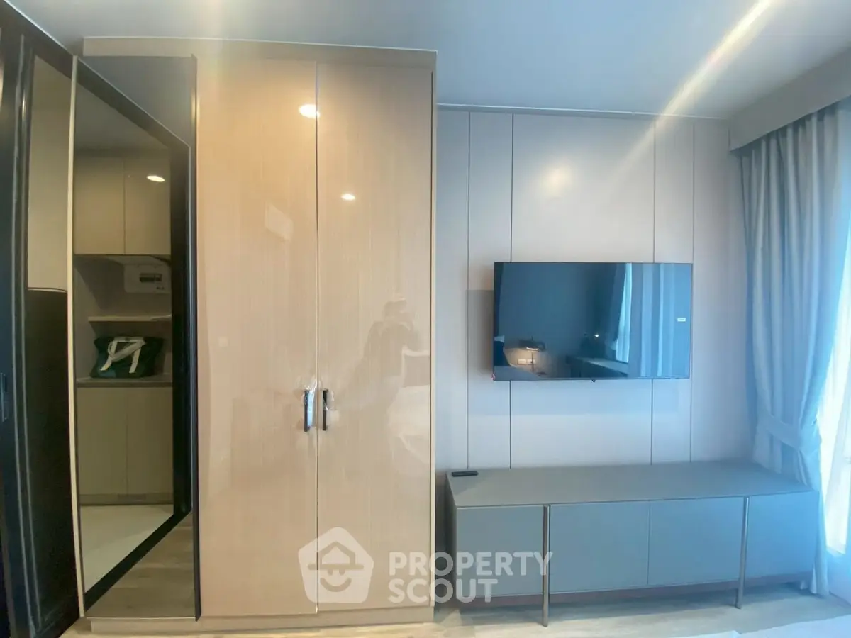 Modern living room with sleek TV setup and stylish wardrobe