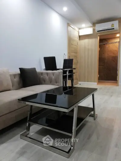 Modern living room with sleek black coffee table and cozy beige sofa