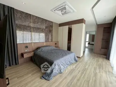 Spacious modern bedroom with elegant wood flooring and stylish decor