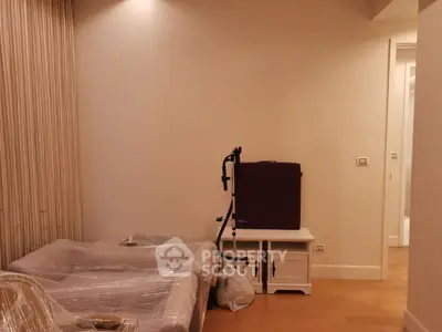 Cozy living room with wrapped furniture and exercise equipment, ideal for modern living.