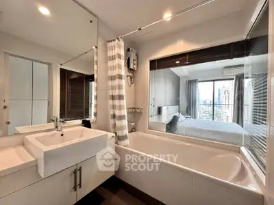 Modern bathroom with bathtub and city view from adjacent bedroom