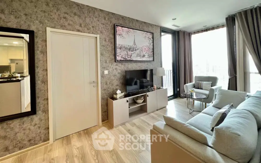 Modern living room with elegant decor and natural light, featuring a cozy sofa and stylish TV unit.