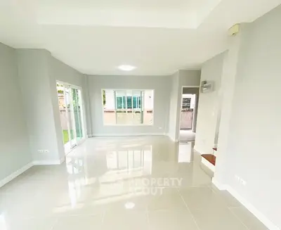 Spacious modern living room with large windows and glossy tile flooring