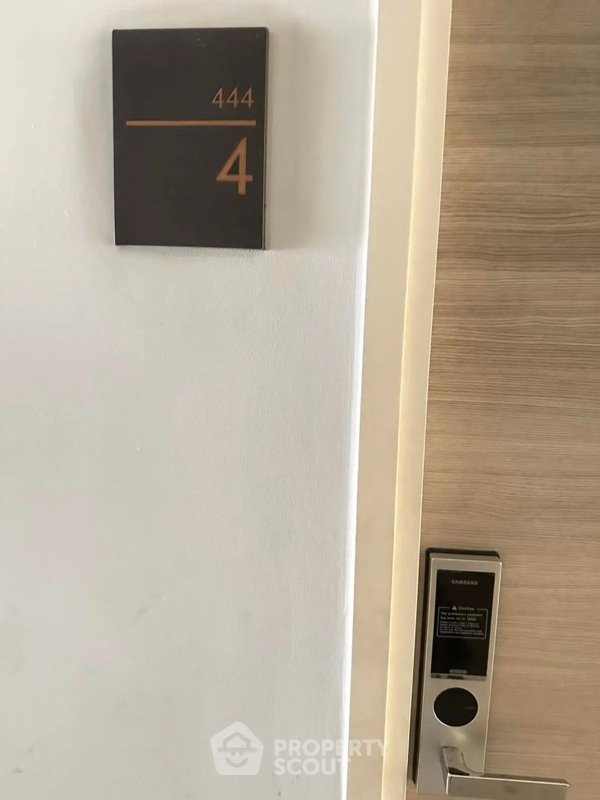Modern apartment entrance with electronic lock and room number 444.