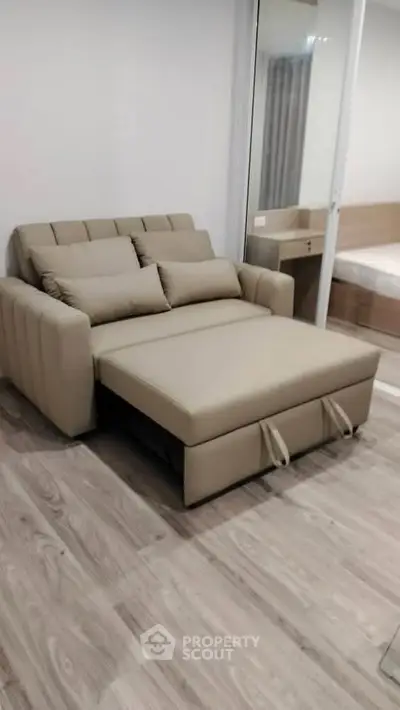Modern living room with stylish beige sofa bed and wooden flooring
