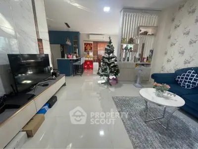 Spacious living room with modern decor and Christmas tree, featuring open layout and stylish furnishings.