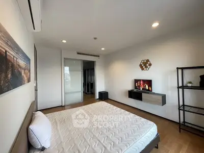 Spacious modern bedroom with stylish decor and ample natural light, featuring a sleek wall-mounted TV and minimalist furnishings.