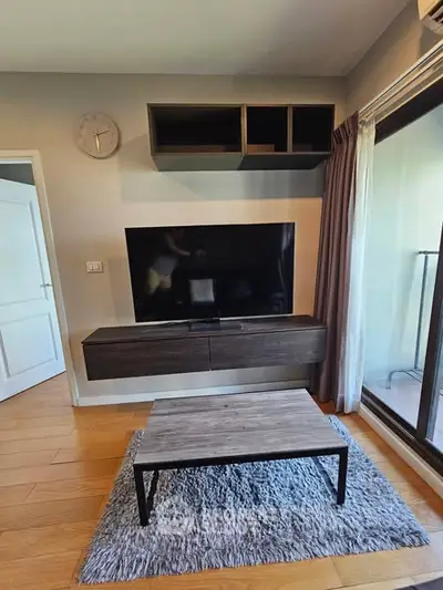 Modern living room with wall-mounted TV and stylish furniture