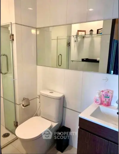 Modern bathroom with glass shower and sleek fixtures in a contemporary home.