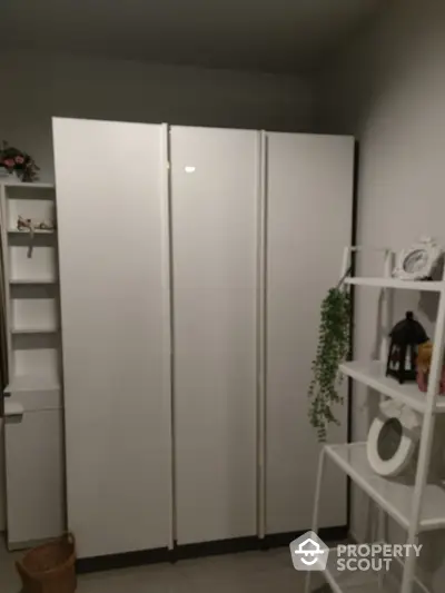 Modern storage room with sleek white cabinets and decorative shelving