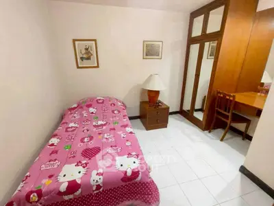 Cozy bedroom with single bed, wooden wardrobe, and study desk in a bright interior.