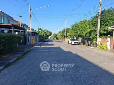 Charming suburban street view with modern houses and lush greenery, perfect for family living.