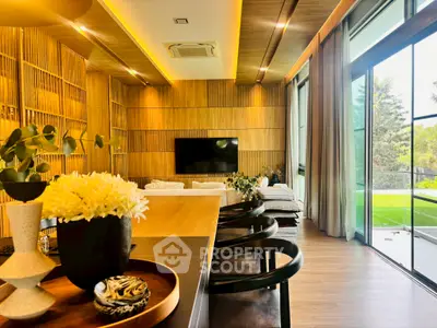 Luxurious modern living room with wooden accents and large windows opening to a garden view.