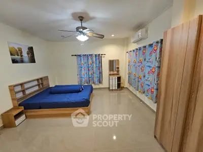 Spacious bedroom with modern furnishings and vibrant curtains