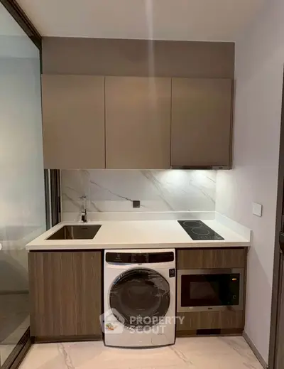 Modern compact kitchen with integrated appliances and sleek cabinetry