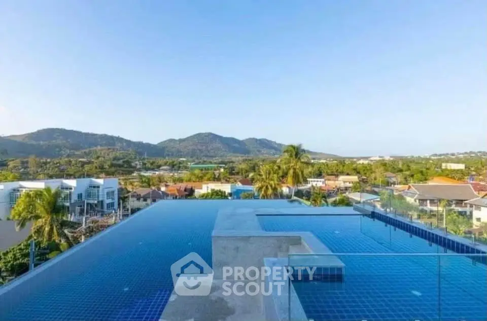 Stunning rooftop infinity pool with panoramic mountain views in a luxurious residential complex.