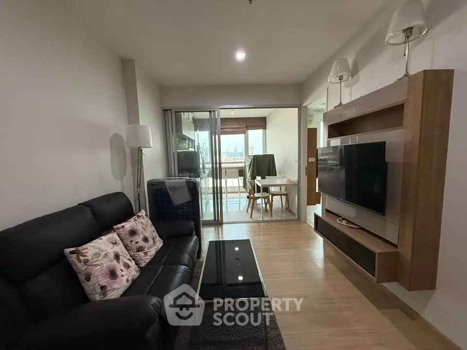 Modern living room with sleek furniture and city view from balcony