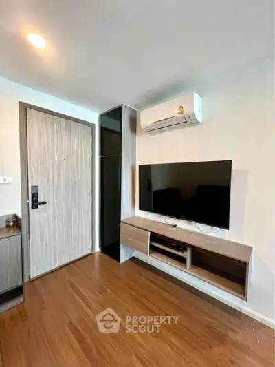 Modern living room with sleek wooden flooring and mounted TV unit