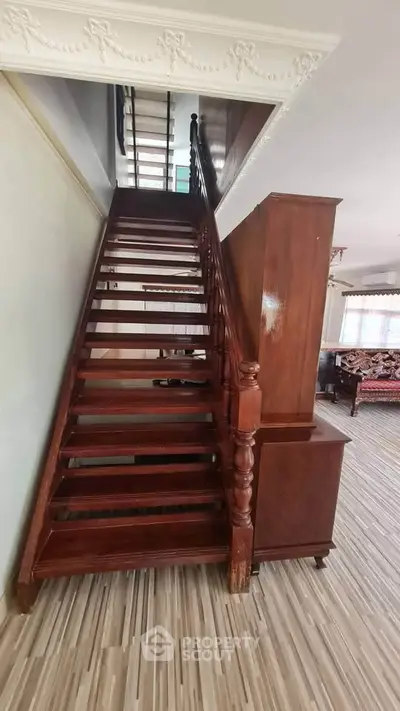 Elegant wooden staircase in a spacious living area with stylish decor