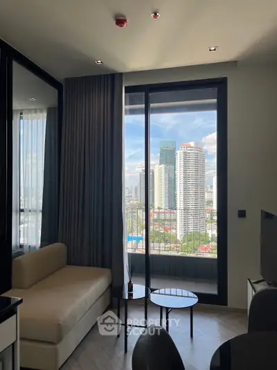 Modern living room with city view, featuring sleek furniture and large windows for natural light.
