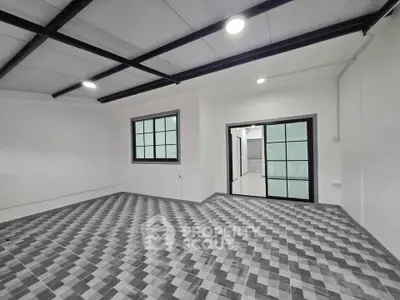 Spacious modern room with stylish checkered flooring and large windows, perfect for versatile use.