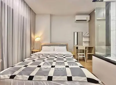 Modern bedroom with stylish decor and natural light, featuring a cozy bed and sleek furnishings.
