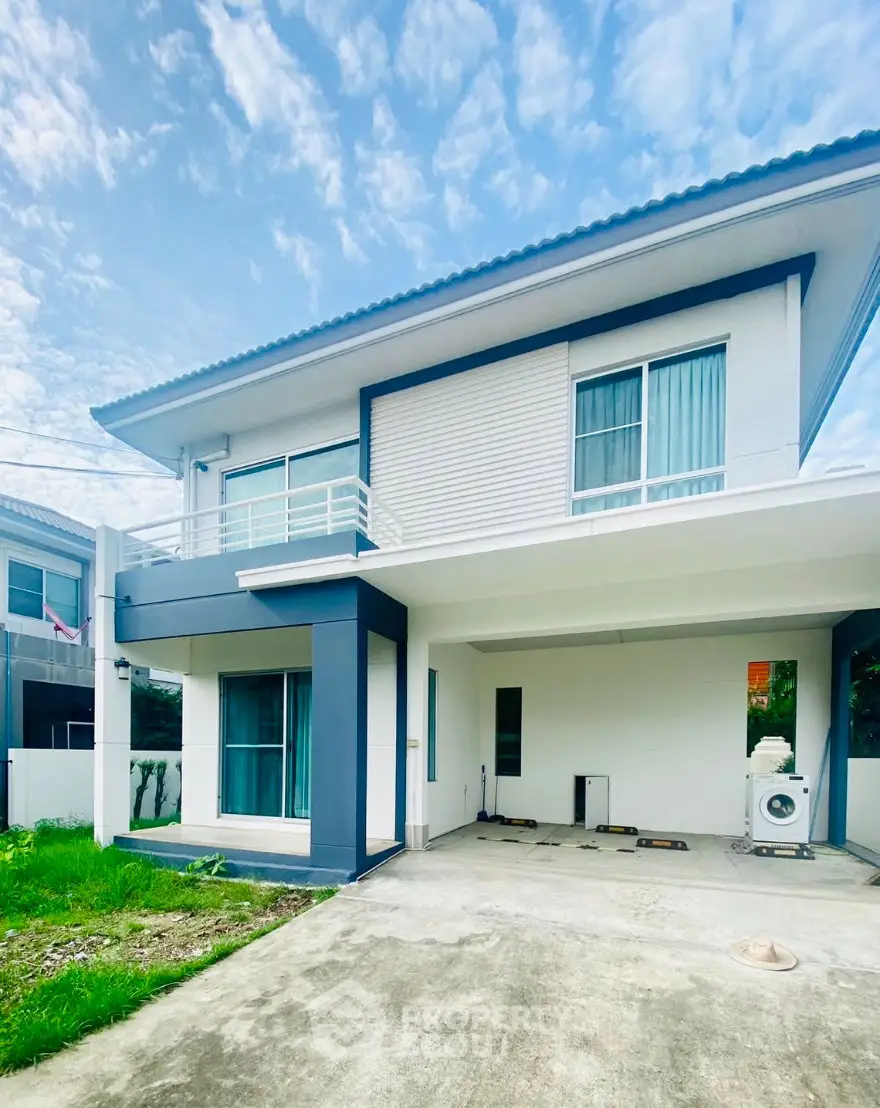 Modern two-story house with sleek design and spacious driveway in a serene neighborhood.
