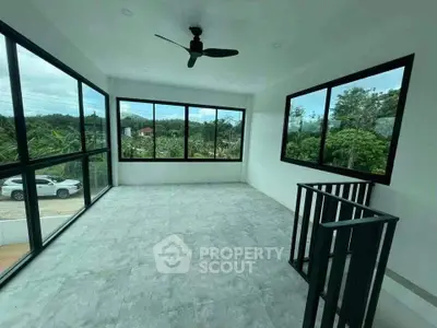 Spacious room with large windows offering scenic views, ideal for a bright and airy living space.
