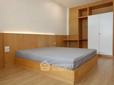 Modern minimalist bedroom with wooden accents and built-in storage solutions.